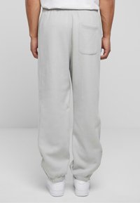 Helle graue Sweatpants mit einem elastischen Bund und einer einzigen Gesäßtasche, ausgestattet mit gerippten Bündchen an den Knöcheln für eine schmal zulaufende Passform.