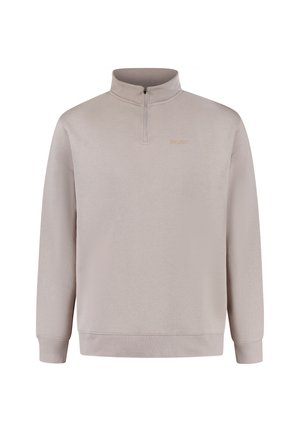 Felpa leggera beige chiaro con zip fino a un quarto, maniche lunghe, polsini a coste e un logo ricamato discreto sul petto. Tessuto morbido e texturizzato.