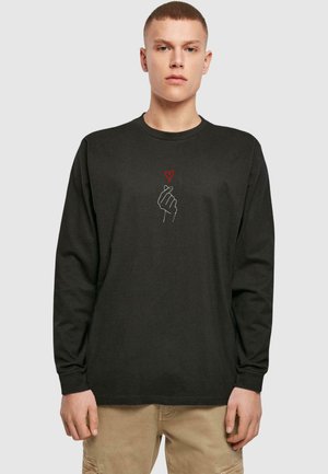 Black long-sleeve t-shirt featuring a white hand design with a red heart. Made of soft fabric, it has a round neck and relaxed fit.