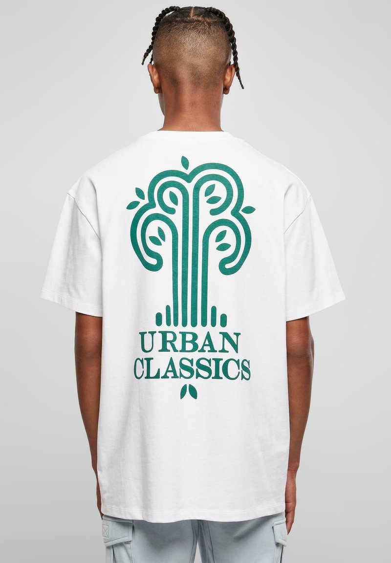 Balta medvilninė marškinėliai su dideliu žaliu grafiniu dizainu ir tekstu "URBAN CLASSICS" ant nugaros; laisvas fasonas ir trumpomis rankovėmis.