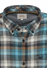 Gekruist flanel overhemd in blauw, zwart, bruin en wit. Beschikt over een button-down kraag, twee zwarte knopen en een label binnenin de kraag.