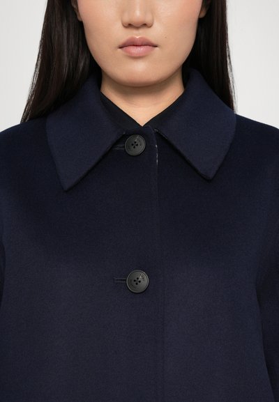 Navyblauwe wollen jas met een puntige kraag, sluiting met zwarte knoop aan de voorkant en een gladde textuur. Minimalistisch ontwerp, zonder patronen.