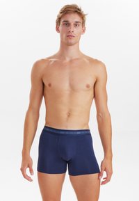 Navyblaue Boxershorts aus weichem Stoff, mit tailliertem Schnitt, elastischem Bund, auf dem "JBS Underwear" gedruckt ist, und eng anliegendem Sitz.