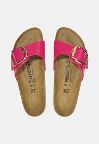 Sandali in pelle sintetica rosa con una larga tracolla e fibbia dorata. Suola in sughero con taglia 38, etichettata "Birkenstock", suola piatta senza battistrada.