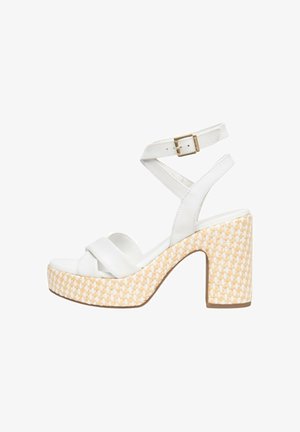 Sandale blanche à talon haut avec semelle plateforme beige tissée, bride de cheville avec boucle dorée et brides croisées à l'avant.