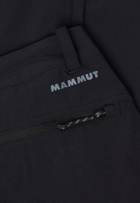 Černé turistické kalhoty s kapsou na zip, plochým pasem a logem na přední straně. Vyrobené z lehkého a odolného materiálu.