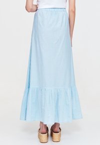 Jasnoniebieska maxi spódnica w paski z rozkloszowanym dołem, wykonana z miękkiego materiału. Posiada elastyczny pas i sięga poniżej kostek.