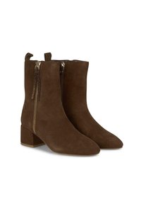 Stivaletti alla caviglia in suede marrone con punta affusolata, tacco a blocco grosso, cerniere laterali e pon pon decorativi per un dettaglio accentuato.