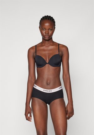 Black padded bra with adjustable straps, paired with black underwear featuring a pink "PIECES" waistband. Smooth, stretchy fabric.