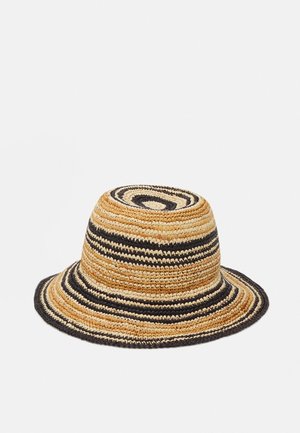 Chapeau seau en paille tissée avec des rayures horizontales alternées noir et naturel beige, et un bord légèrement évasé sur un fond blanc.