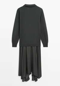 Maglione grigio scuro a maniche lunghe con colletto, sovrapposto a una gonna asimmetrica drappeggiata coordinata, su sfondo bianco.