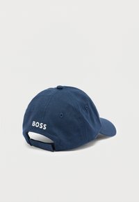 Cappello blu navy in cotone, con visiera curva, logo ricamato "BOSS" in bianco sul retro e chiusura con cinturino regolabile.