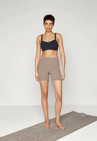 Mustra mustraspaga mustkome ka primad tuub ja tanvärvi kõrge talje lühikesed püksid. Sujuv kangas, naha vastav disain ning lühikeste pükste logosilt.