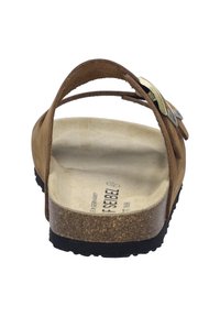 Brown leather sandal with a cork sole, adjustable strap featuring a metal buckle, flat design, and textured footbed. Black rubber outsole.