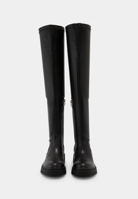 Bottes en cuir noir montantes jusqu'au genou, finition lisse, fermetures éclair latérales et semelle texturée pour l'adhérence. Design minimaliste sans motifs apparents.