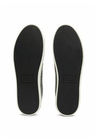 Black textured rubber soles with a white edge, featuring a raised logo in the center. Designed for comfort and traction.