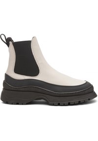Chelsea boot in beige and black, featuring a durable leather upper, elastic side panels, thick black sole, and textured detailing.