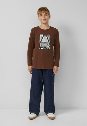 Braunes langärmliges Baumwoll-T-Shirt mit einem Grafikdruck und dem Schriftzug "TODAY". Kombiniert mit locker sitzender dunkelblauer Jeanshose und weißen Turnschuhen.