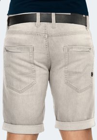 Hellgraue Denim-Shorts mit umgeschlagenen Säumen, die zwei Gesäßtaschen und einen am Bund sichtbaren schwarzen Ledergürtel aufweisen.