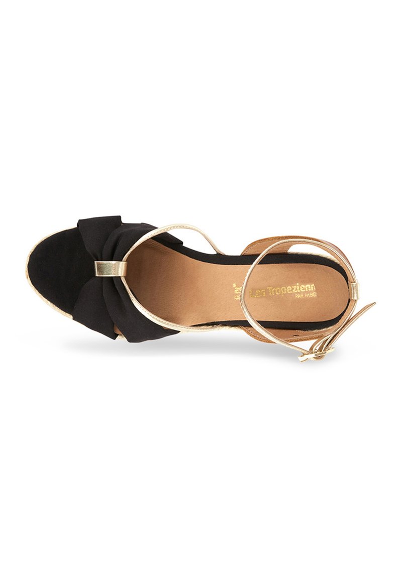 Black fabric sandal with a bow detail, gold-tone hardware, open toe design, and ankle strap. Soft insole with a light brown texture.