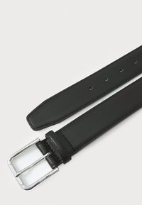 Curea din piele neagră cu o textură netedă, având o cataramă din metal argintiu lucios și mai multe găuri pentru ajustare.