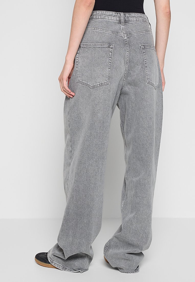 Jeans grigi, a gamba larga, realizzati in denim con un lavaggio sbiadito. Presentano due tasche posteriori e una vita alta, offrendo una vestibilità comoda.