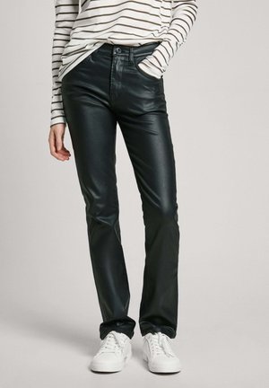 Mustat tekonahkahousut slim fit -leikkauksella ja kevyellä kiillolla, joissa on nappikiinnitys ja viisi taskua, käytetty raidallisen paidan ja valkoisten lenkkareiden kanssa.