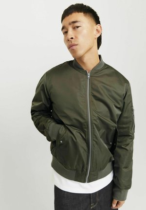 Veste bomber vert olive avec fermeture éclair, poignets côtelés et poches latérales. Fabriquée en tissu lisse avec une coupe décontractée.
