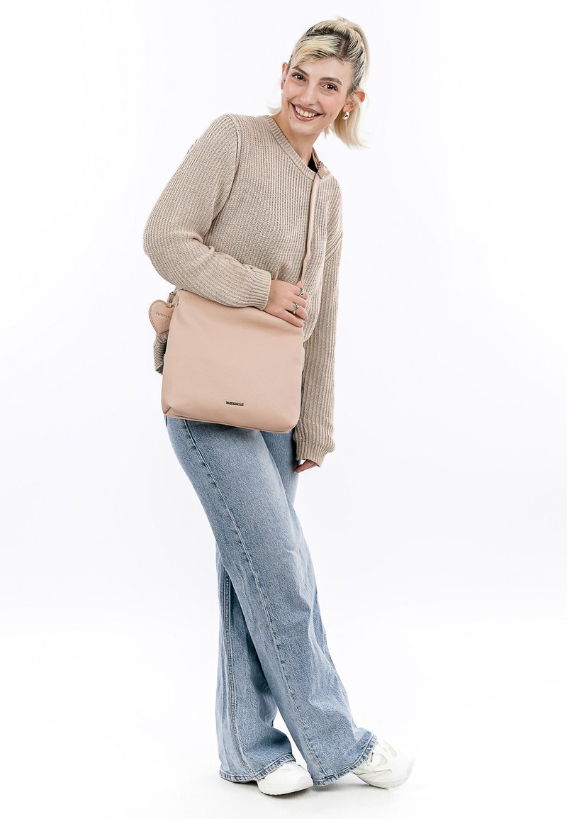 Beige leather crossbody bag with a smooth texture, rectangular shape, and adjustable strap. Features subtle branding on the front.