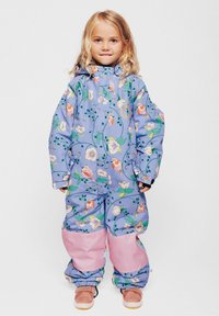 Mono impermeable en púrpura claro con patrones florales y de pájaros; presenta adornos rosas en las piernas, la cremallera frontal y la capucha.