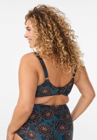 Plavková súprava s tmavým petrolejovým základom, kvetinovým vzorom v odtieňoch hnedej, nastaviteľnými ramienkami a zapínaním na sponu vzadu.