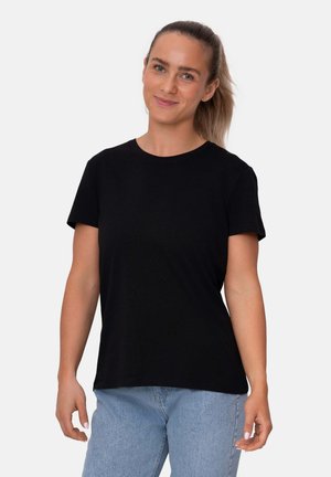 Sort bomulds T-shirt med rund halsudskæring og korte ærmer, parret med lyseblå denim jeans. Glat tekstur, afslappet pasform.