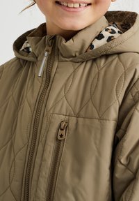 Chaqueta acolchada marrón claro con capucha, con un forro de estampado de leopardo y cierre frontal con cremallera. Incluye un tirador de cremallera en forma de estrella decorativa.
