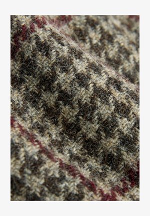 Tekstuirana tkanina z rjavim in bež houndstooth vzorcem, ki ima subtilno bordo rdečo akcentno črto. Mehka, volnena podobna material.