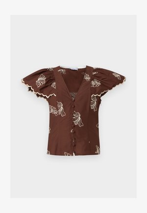Καφέ μπλούζα με βαθύ V-λαιμόκοψη, κουμπιά καλυμμένα με ύφασμα, φουσκωτά μανίκια πεταλούδας, κυματιστά τελειώματα και λευκή κεντητή ανθοδέσμη.