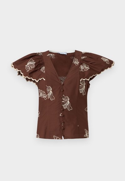 Καφέ μπλούζα με βαθύ V-λαιμόκοψη, κουμπιά καλυμμένα με ύφασμα, φουσκωτά μανίκια πεταλούδας, κυματιστά τελειώματα και λευκή κεντητή ανθοδέσμη.