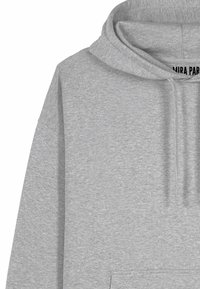 Felpa grigia realizzata in tessuto morbido, con tasca a marsupio, cappuccio con coulisse e orlo a costine. Texture liscia con design semplice.