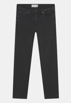 Czarne dżinsy z denimu o wąskim kroju, z pięcioma kieszeniami, srebrnymi okuciami i płaskim pasem. Gładka faktura z minimalnie widocznym przeszyciem.