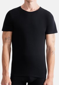 Black short-sleeved t-shirt, made of smooth fabric. Features a crew neckline, fitted shape, and subtle stitching details along the hem.