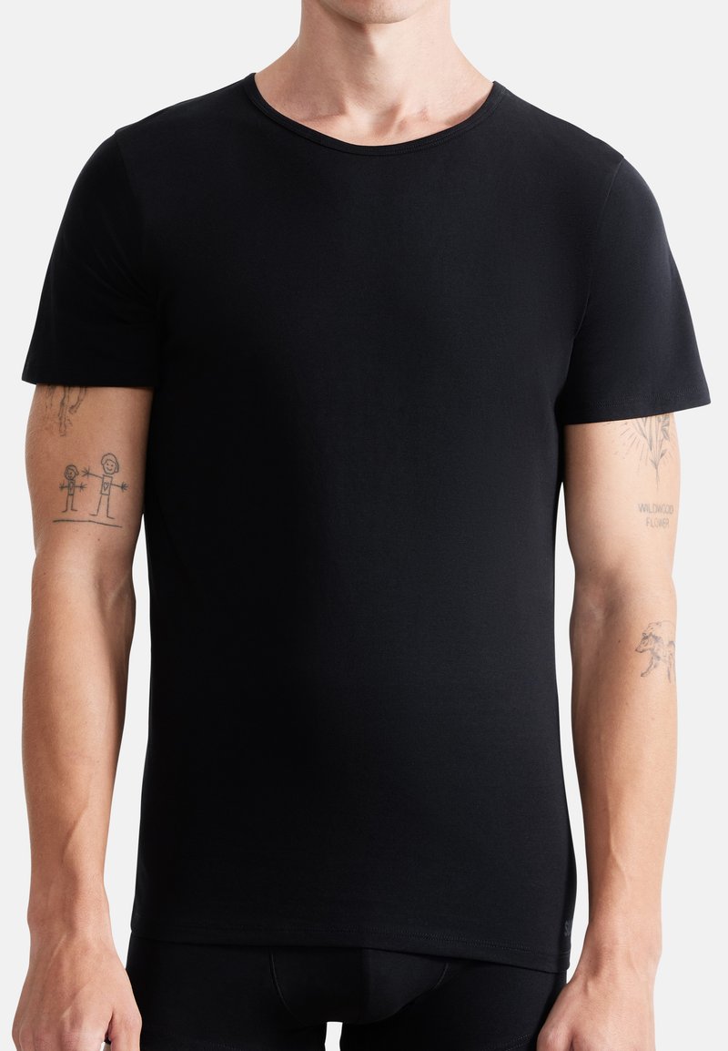 Black short-sleeved t-shirt, made of smooth fabric. Features a crew neckline, fitted shape, and subtle stitching details along the hem.