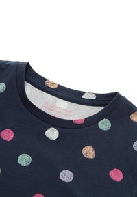 Marineblauw T-shirt met een ronde hals en multicolour glinsterende polkadots, met een label aan de binnenkant met maat- en wasinstructies.