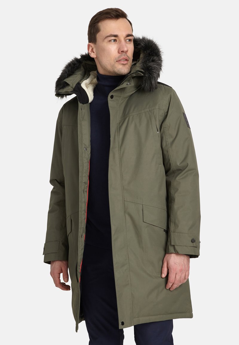 Olivza zaļa parka ar kažokādas odere kapuci, ar rāvējslēdzēju priekšā, sānu kabatām un sarkanu akcentu apmalē. Mīksta tekstūra.