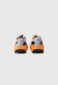 Chaussures de sport grises et oranges avec un revêtement texturé, un talon supportant et une semelle en mousse orange. Des accents noirs décorent les côtés et le talon.