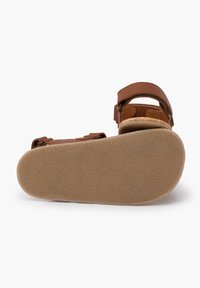 Brązowe skórzane sandały z dwiema regulowanymi paskami, korkową wkładką i teksturowaną gumową podeszwą. Formowane dla komfortu i stabilności.