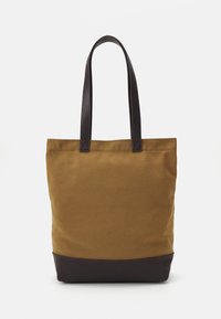 Braune Canvas-Tote-Bag mit dunkelbraunem Lederboden, zwei Schulterriemen und einem schlichten, ungeschmückten Design. Stabil und funktional.