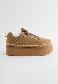 Sneaker platform in suede marrone chiaro con fodera in pelliccia sintetica, dettagli in pizzo decorato e cuciture lungo la suola.