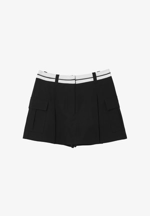 Shorts neri con una vita bianca decorata con cuciture, due tasche laterali e un design strutturato. Il materiale sembra liscio e leggero.