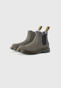 Grå vanntette Chelsea-boots med kunstpelsdetaljer, elastiske sidepaneler og gul søm på sålen. Flat gummisåle for stabilitet.