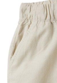 Lichtbeige elastische taillebroek met zijzakken, gemaakt van een zachte, gestructureerde stof, met afgewerkte naden en een relaxte pasvorm.