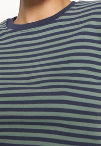 Randig t-shirt med smala horisontella ränder i marinblått och grönt. Tillverkad av mjuk tyg med rundad hals och minimala sömmar.